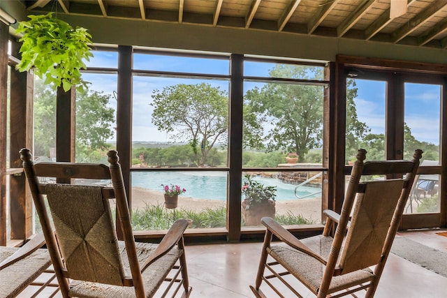 sunroom / solarium featuring beam ceiling, a water view, french doors, and wood ceiling