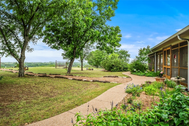 view of yard featuring a rural view and a sunroom