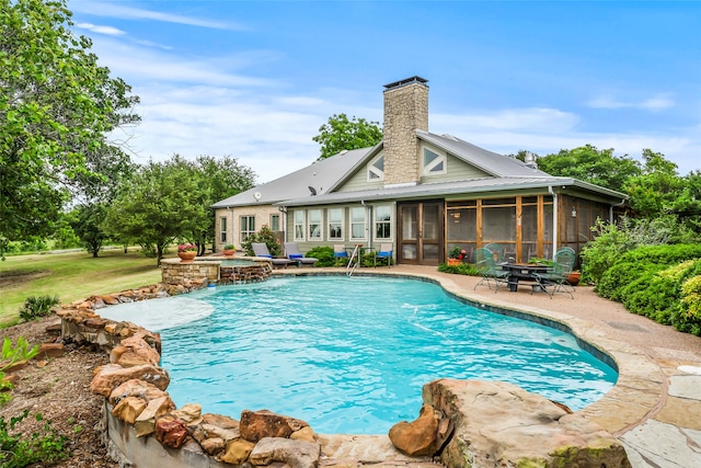 view of swimming pool featuring a sunroom and a patio