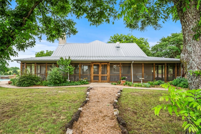 view of front facade featuring a sunroom and a front yard