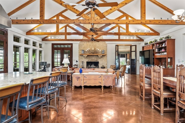 dining space with a healthy amount of sunlight, a fireplace, and high vaulted ceiling