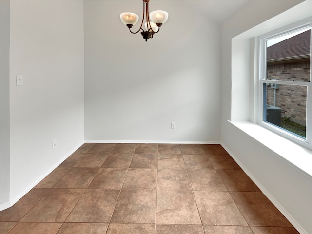 empty room with a notable chandelier and tile flooring