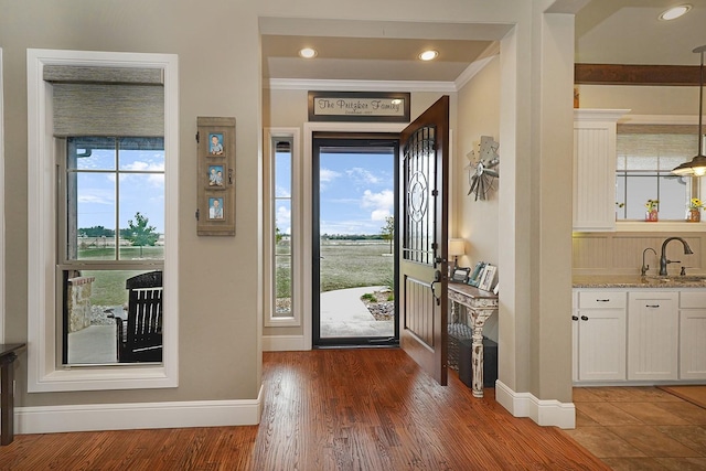 entryway featuring crown molding, sink, and dark hardwood / wood-style flooring