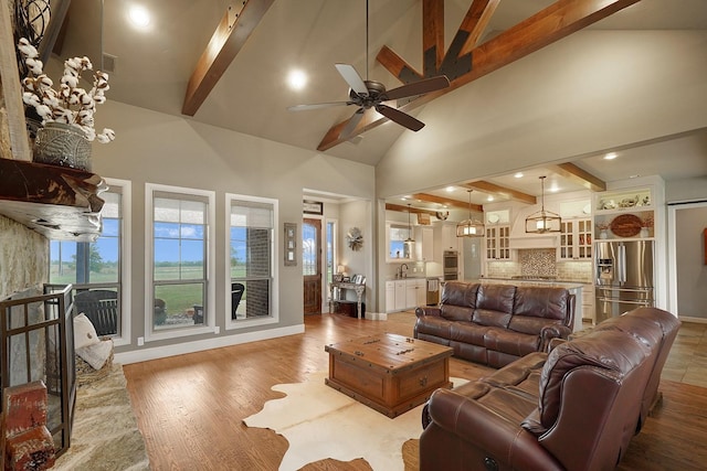 living room featuring sink, ceiling fan, beam ceiling, high vaulted ceiling, and light hardwood / wood-style floors