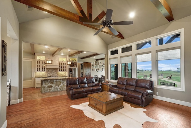 living room with beam ceiling, hardwood / wood-style flooring, plenty of natural light, and ceiling fan