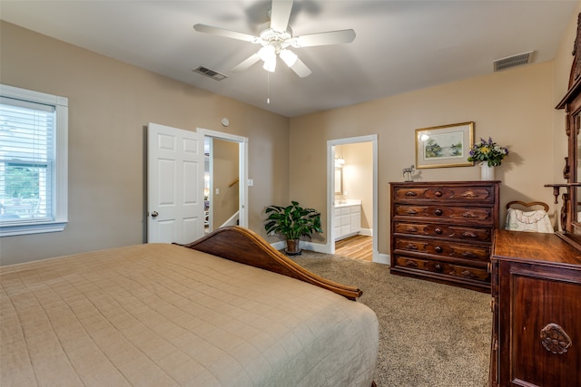 bedroom with ensuite bathroom, ceiling fan, and light colored carpet