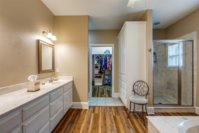 bathroom featuring tile floors, a shower with door, ceiling fan, and large vanity