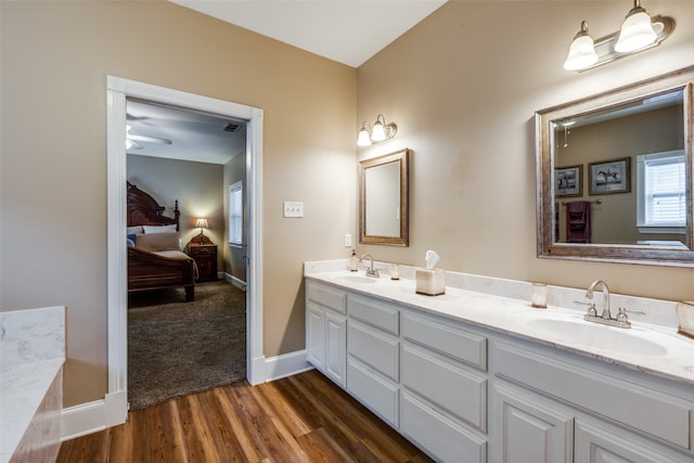 bathroom featuring ceiling fan, oversized vanity, double sink, and hardwood / wood-style flooring