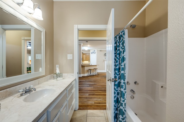 bathroom with hardwood / wood-style floors, vanity with extensive cabinet space, and shower / tub combo with curtain