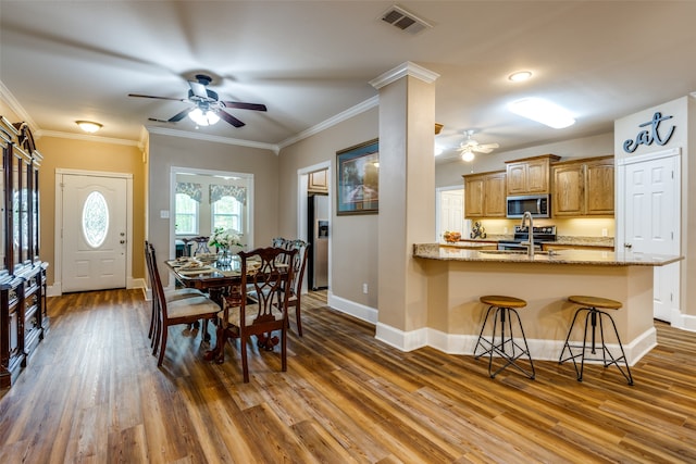 dining space featuring ceiling fan, crown molding, and wood-type flooring