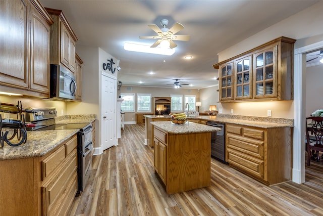 kitchen with stainless steel appliances, hardwood / wood-style floors, a center island, and ceiling fan