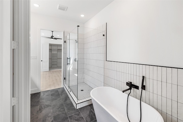 bathroom with tile patterned flooring, ceiling fan, independent shower and bath, and tile walls