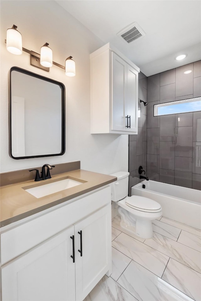 full bathroom featuring toilet, vanity, and tiled shower / bath