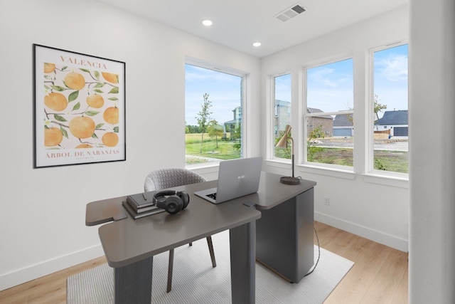 office space with a healthy amount of sunlight and light hardwood / wood-style floors