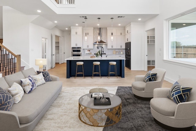 living room featuring sink and light hardwood / wood-style floors