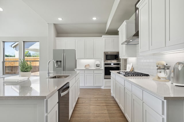 kitchen with light hardwood / wood-style floors, wall chimney exhaust hood, tasteful backsplash, and stainless steel appliances