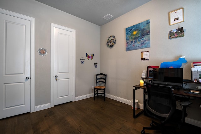 office with dark wood-type flooring, visible vents, and baseboards