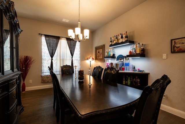 dining area featuring baseboards, a dry bar, dark wood finished floors, and a notable chandelier