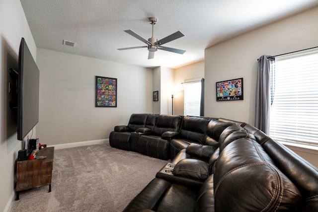 living room featuring a ceiling fan, plenty of natural light, visible vents, and carpet flooring