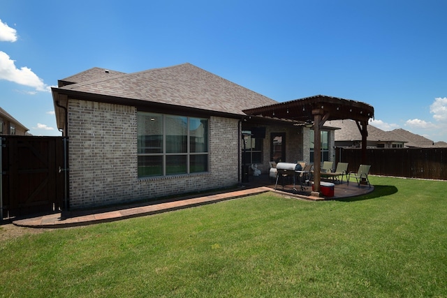 back of property with roof with shingles, brick siding, a patio, a lawn, and fence