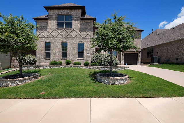 tudor house with concrete driveway, brick siding, and a front lawn