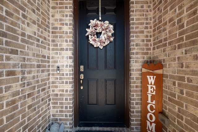 doorway to property featuring brick siding