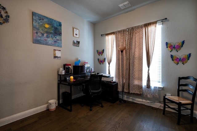 office space with baseboards, visible vents, and dark wood finished floors