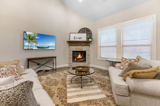 living room with a fireplace, vaulted ceiling, and hardwood / wood-style floors