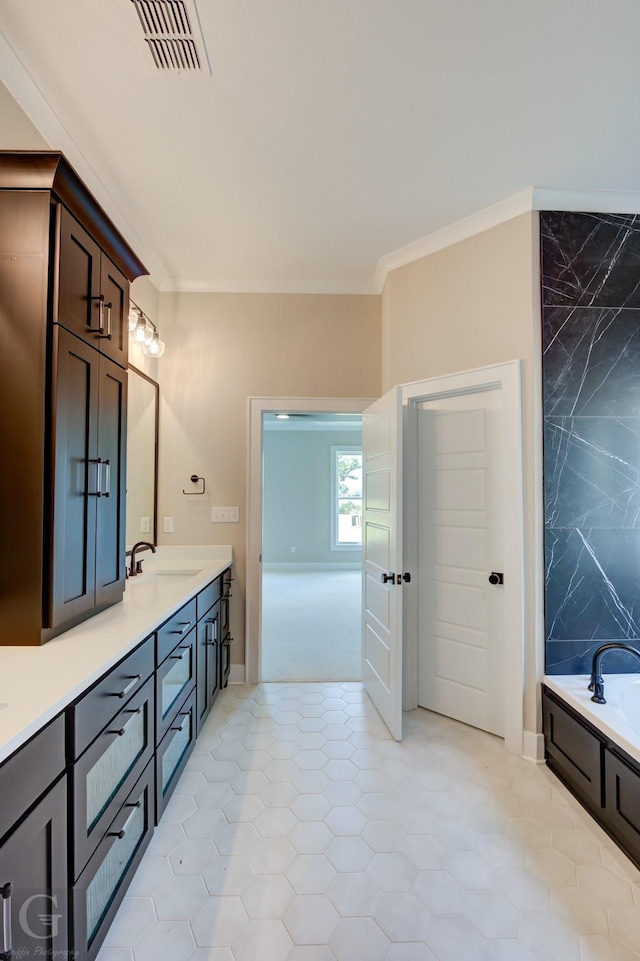 bathroom featuring tile patterned floors, vanity, crown molding, and a bath