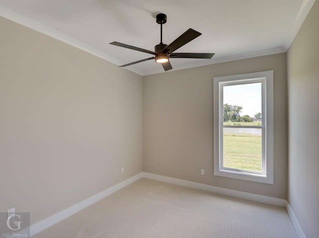 spare room featuring ceiling fan, light colored carpet, and crown molding