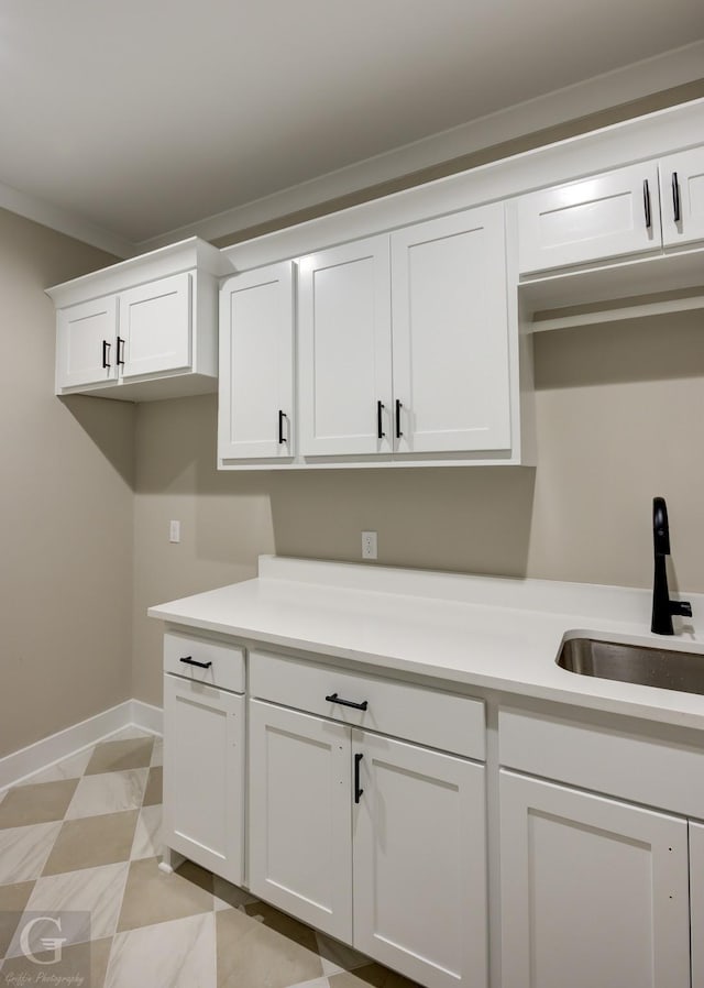 laundry room featuring sink and crown molding