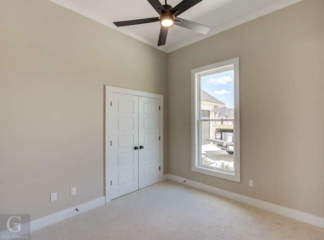 unfurnished bedroom with ceiling fan, a closet, and light colored carpet