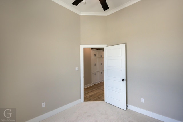 carpeted empty room featuring ceiling fan and crown molding