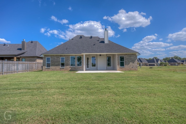 back of property with a yard and a patio