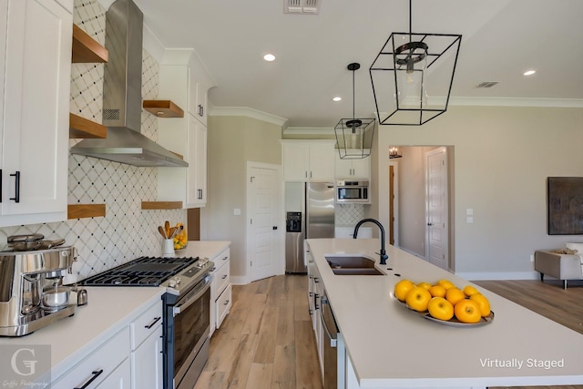 kitchen featuring stainless steel appliances, wall chimney exhaust hood, white cabinets, and sink