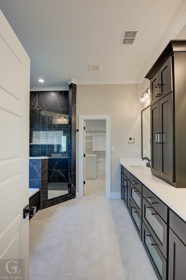 bathroom featuring tile patterned floors, a shower with shower door, and vanity