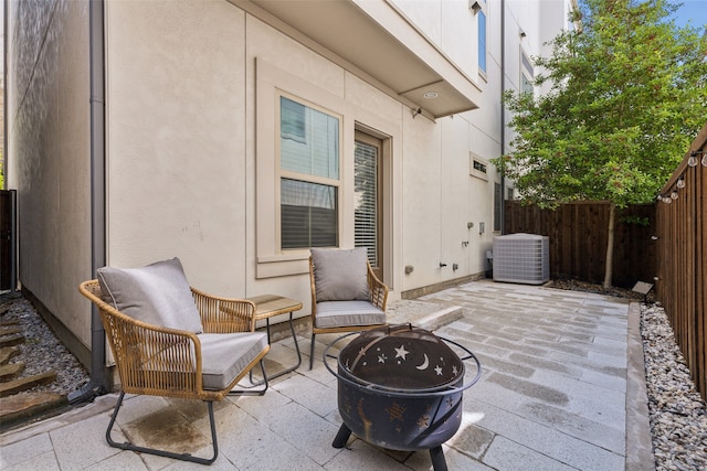 view of terrace with an outdoor fire pit and central AC