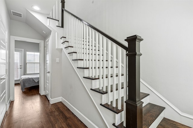 stairway with vaulted ceiling and dark hardwood / wood-style flooring