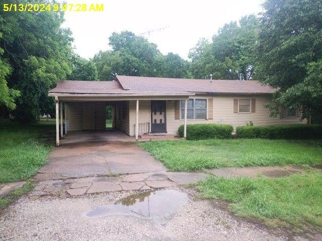 single story home with a front lawn and a carport