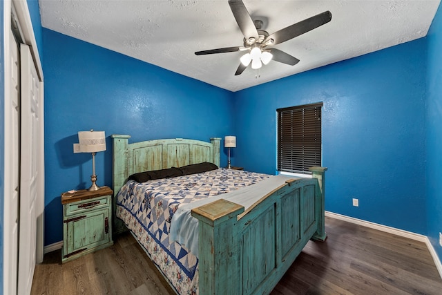 bedroom with ceiling fan, dark hardwood / wood-style flooring, and a textured ceiling