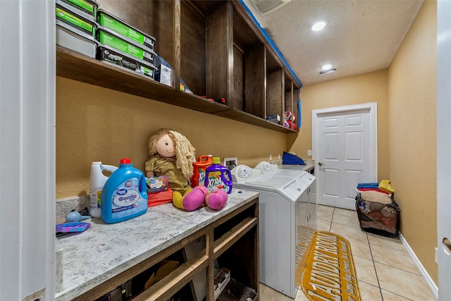 laundry room with washer and dryer, washer hookup, a textured ceiling, and light tile floors