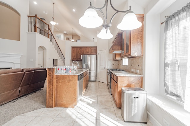 kitchen with custom exhaust hood, decorative light fixtures, backsplash, light tile floors, and appliances with stainless steel finishes