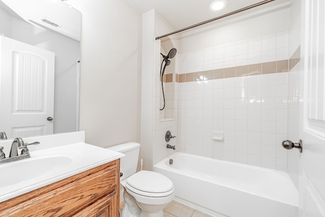 full bathroom with tile floors, tiled shower / bath, vanity with extensive cabinet space, and toilet