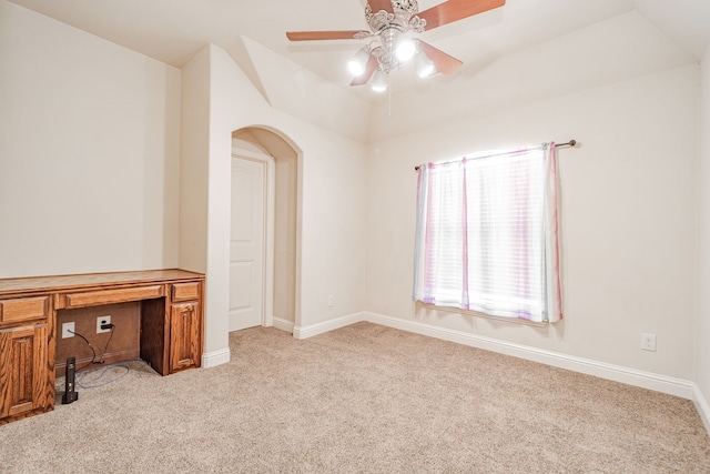 empty room featuring light colored carpet, vaulted ceiling, and ceiling fan