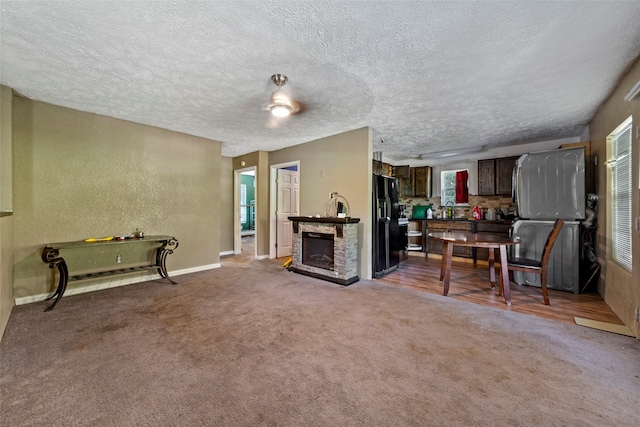 interior space with a stone fireplace, a healthy amount of sunlight, and a textured ceiling