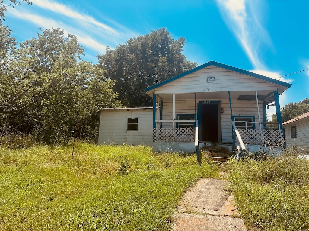 view of front of home featuring a shed and covered porch