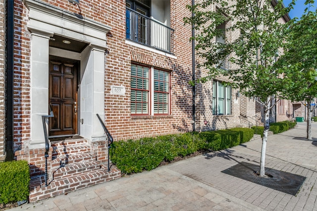 view of exterior entry with a balcony