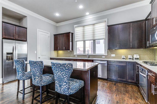 kitchen with stainless steel appliances, dark hardwood / wood-style flooring, a center island, and tasteful backsplash