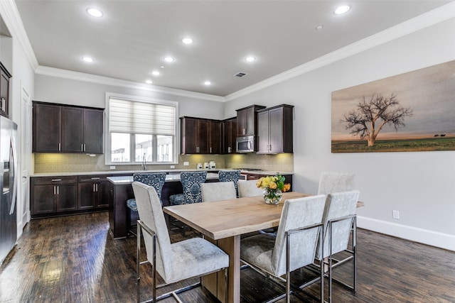 dining space with dark wood-type flooring, sink, and crown molding