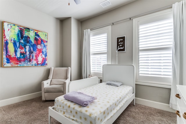 carpeted bedroom featuring multiple windows and ceiling fan